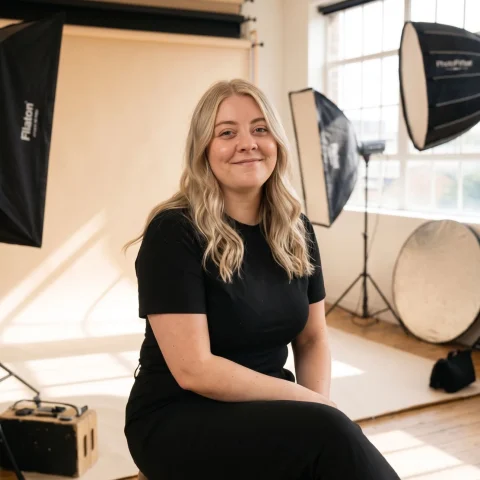 Seated studio portrait of an Allied Health Warrior mentor wearing black, photographed in a bright professional studio.